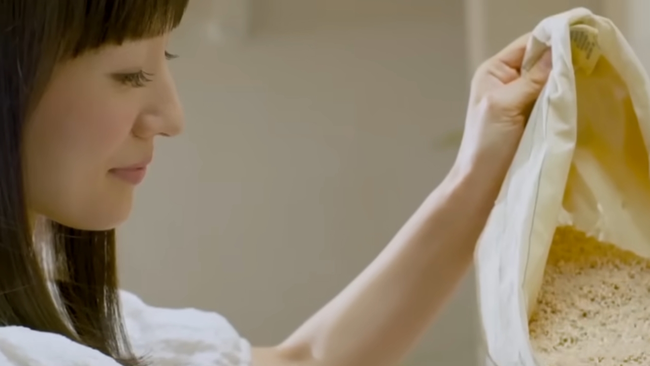 Marie Kondo holds up a white garment as she organizes clothes.